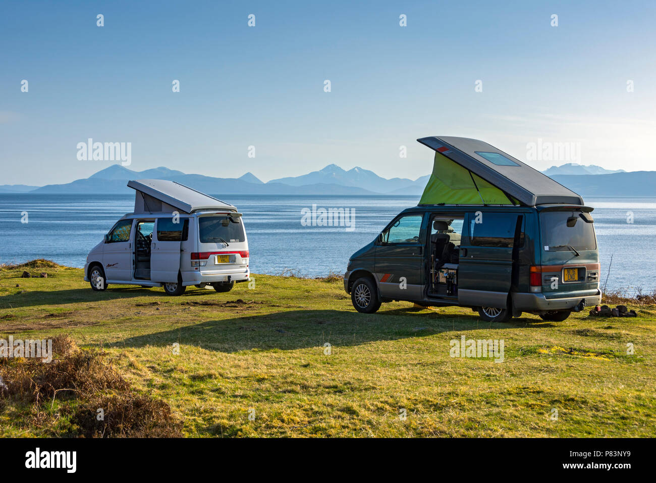 Deux camping-cars Mazda Bongo sur la route côtière près de Verviers, région des Highlands, Ecosse, Royaume-Uni. En regardant vers l'Cuillin Hills de Skye. Banque D'Images