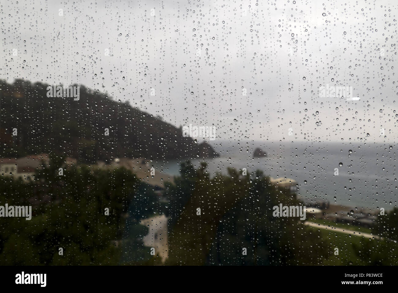 Vue des pluies sur la plage par la fenêtre Banque D'Images
