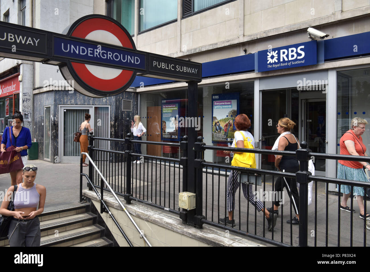 Les gens passent devant la direction générale de la Royal Bank of Scotland bank à côté de la station de métro Notting Hill Gate Banque D'Images