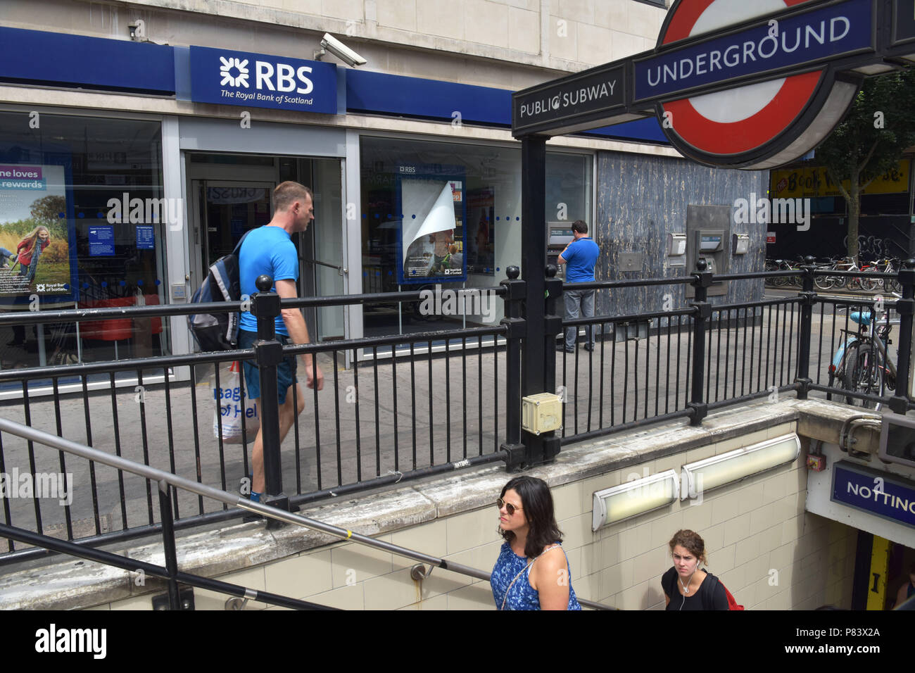 Les gens passent devant la direction générale de la Royal Bank of Scotland bank à côté de la station de métro Notting Hill Gate Banque D'Images