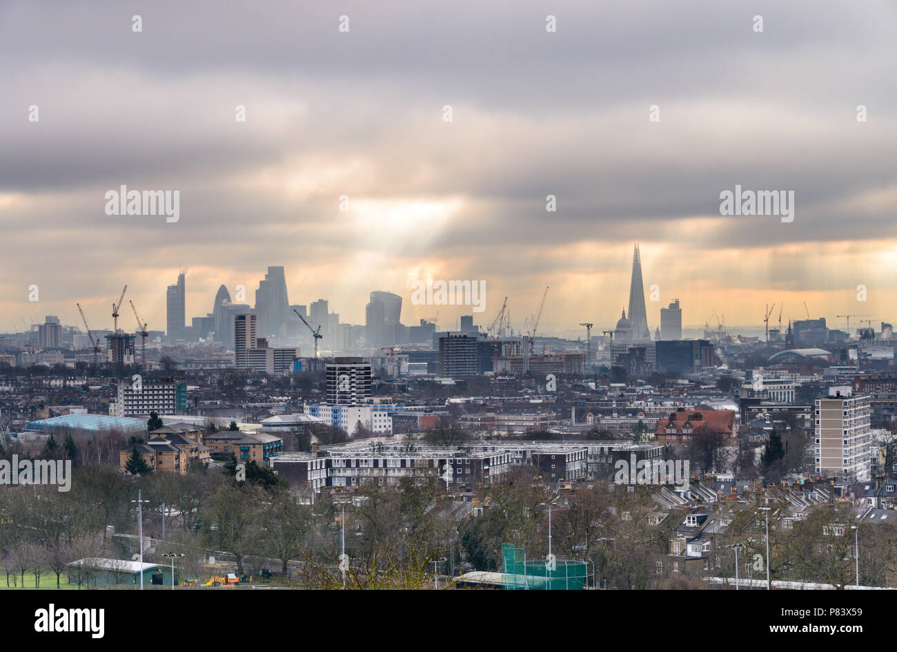 Vue depuis la colline du Parlement à Hampstead Heath en direction de la ville de Londres avec le tesson et cornichon dans un ciel dramatique avec rayons de soleil Banque D'Images