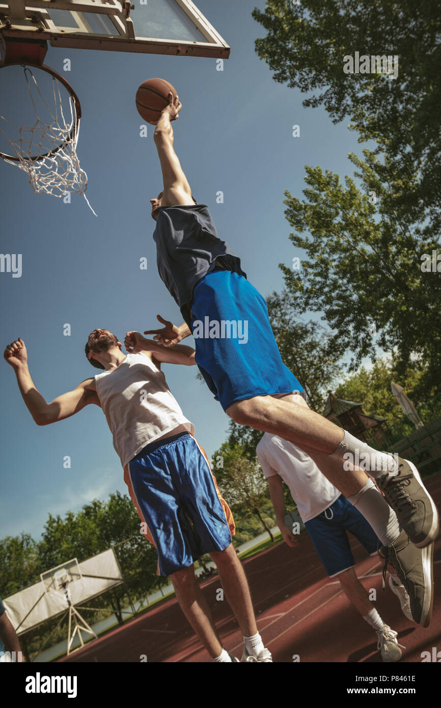 Trois joueurs de basket-ball ont un programme de formation à l'extérieur.  Ils sont en train de jouer et faire de l'action Photo Stock - Alamy