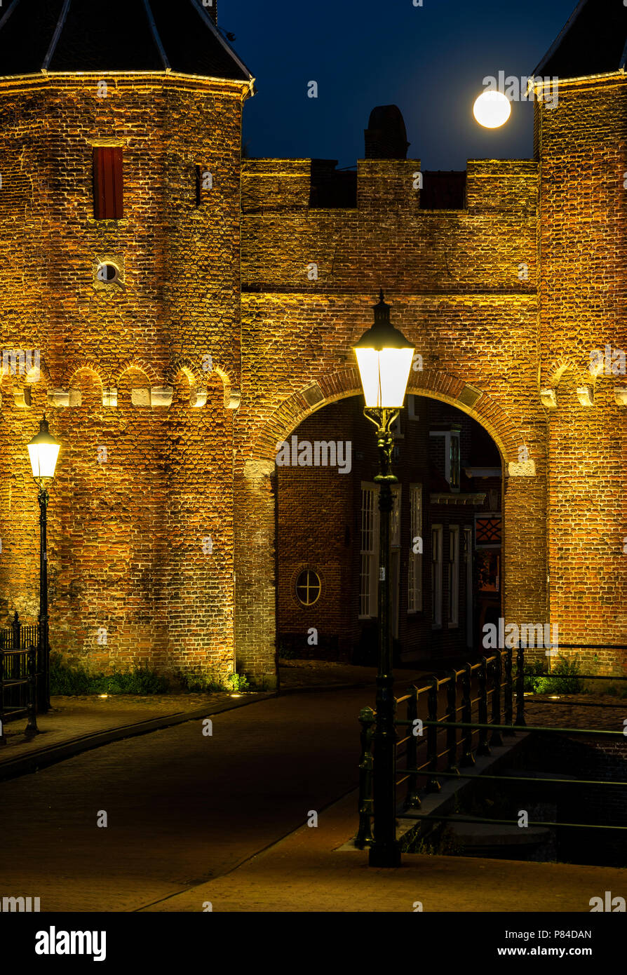 Koppelpoort (gate) dans la soirée avec deux llighted réverbères et pleine lune. Banque D'Images