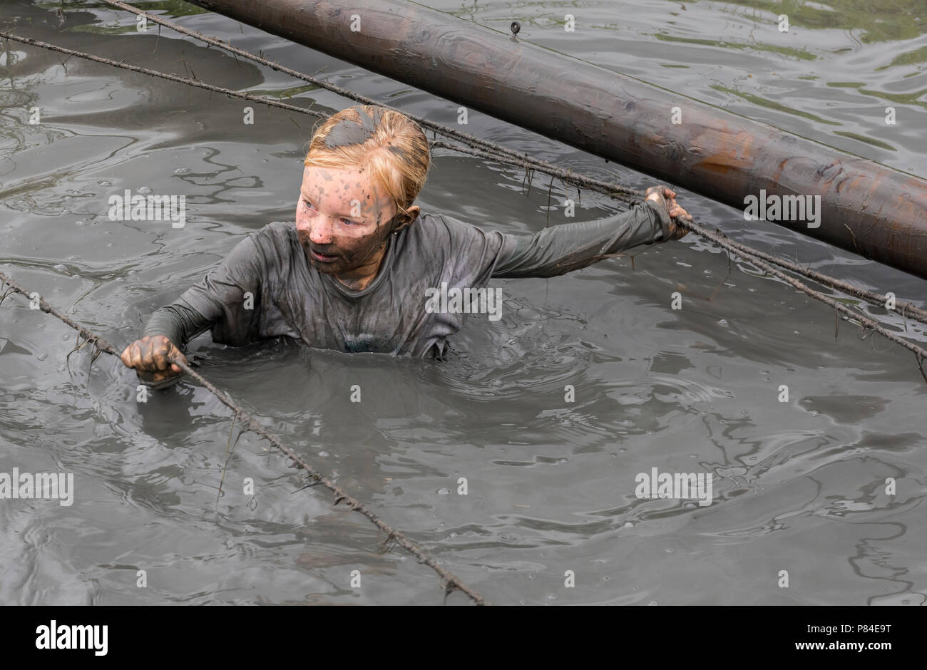 Biddinghuizen, Pays-Bas - le 23 juin 2018 : l'enfant durant un mud run (mudraise, charité) dans la boue et dans l'eau noire. Banque D'Images