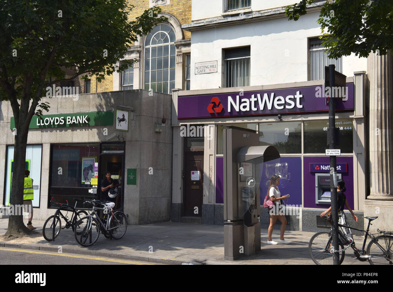 Les gens passent devant les branches de NatWest et banques Lloyds dans Notting Hill Londres Banque D'Images