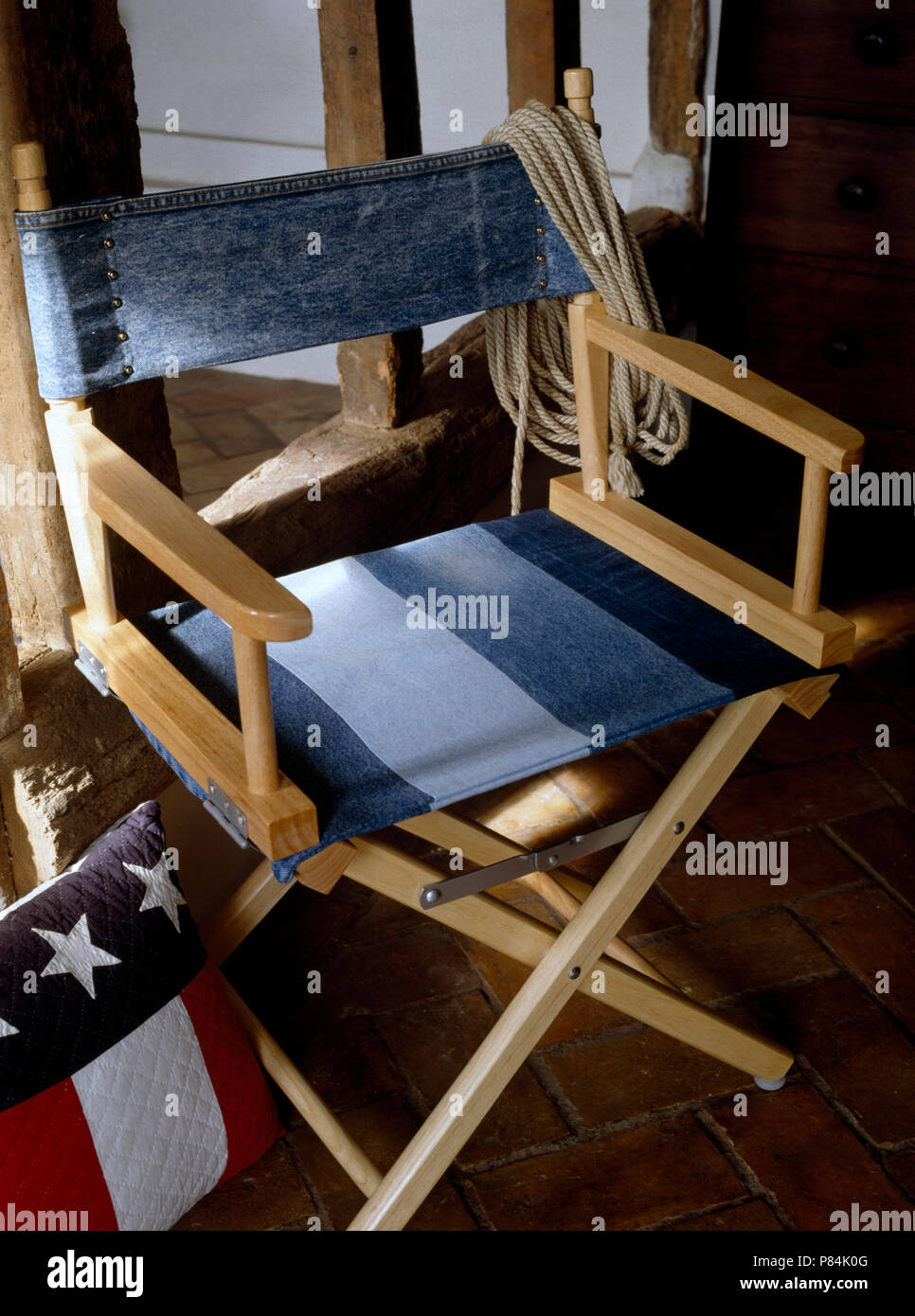 Close-up of a director's chair avec nouveau siège et harnais en bleu de toile et une vieille paire de jeans en denim Banque D'Images