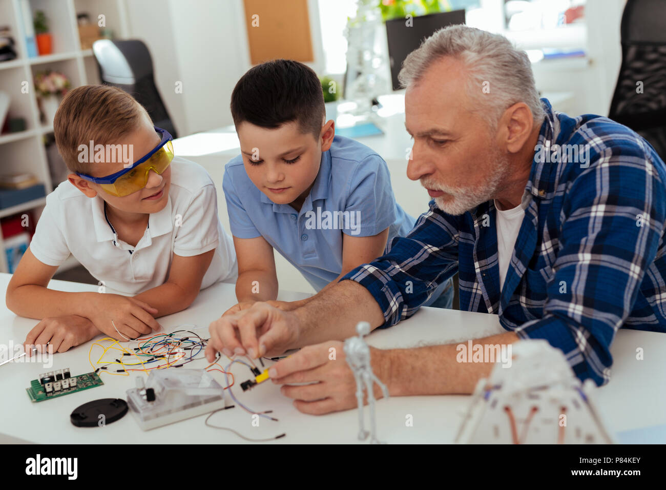 Homme d'âge agréable assis ensemble avec ses petits-enfants Banque D'Images