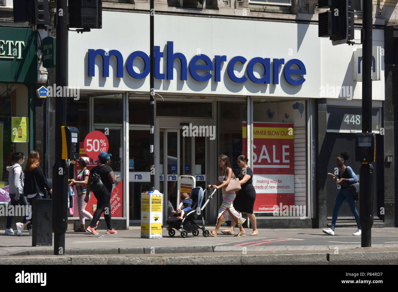 Les gens passent devant une succursale de la détaillant spécialiste Mothercare sur l'Holloway Road au nord de Londres Banque D'Images