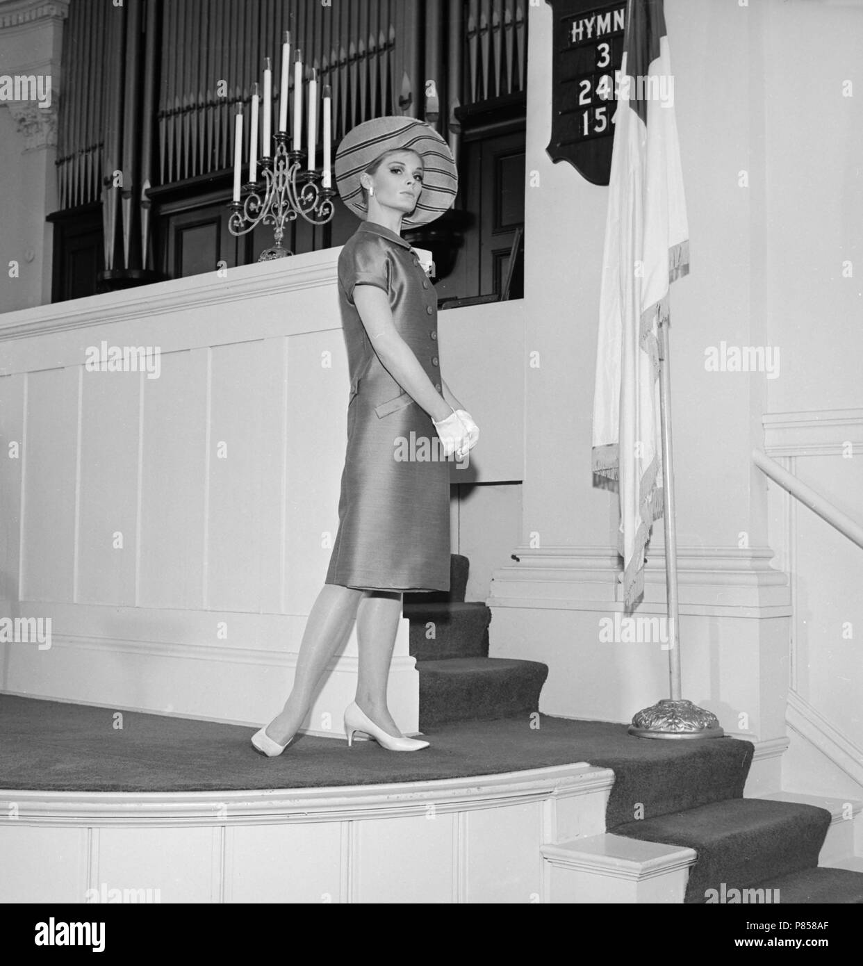 Un modèle établit un poser lors d'un shoot de mode dans une église en Californie, ca. 1965. Banque D'Images