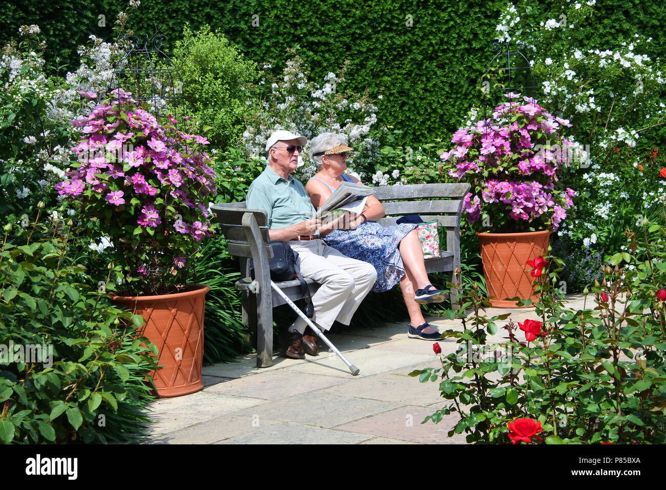 Un couple de personnes âgées assis dans un jardin, RHS Rosemoor, Devon, UK - John Gollop Banque D'Images