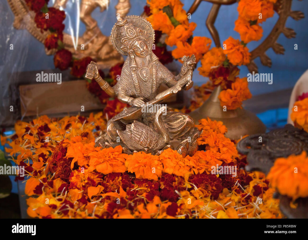 La figure de la Déesse Saraswati. Puja hindoue. L'encens, des offrandes, pétales, fleurs de souci. Indien, traditionnel, autel, religion, vacances, Navratri, still life. Banque D'Images