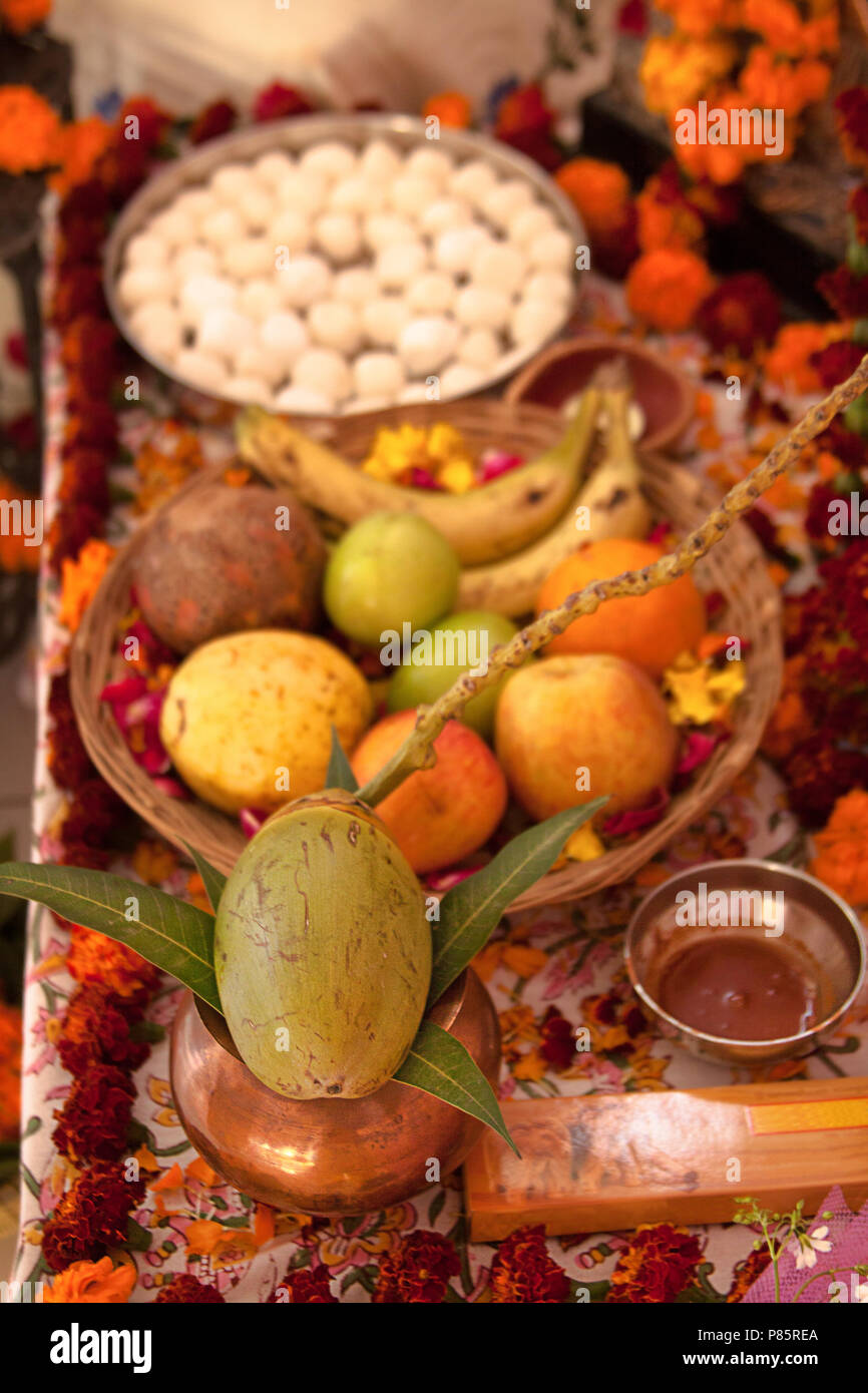 Puja hindoue, offrant aux dieux. L'encens, fruits, noix de coco, bonbons, pétales de rose, fleurs de souci, des statues des dieux. Indien, traditionnel, autel, religion, vacances, Navratri, still life. Banque D'Images