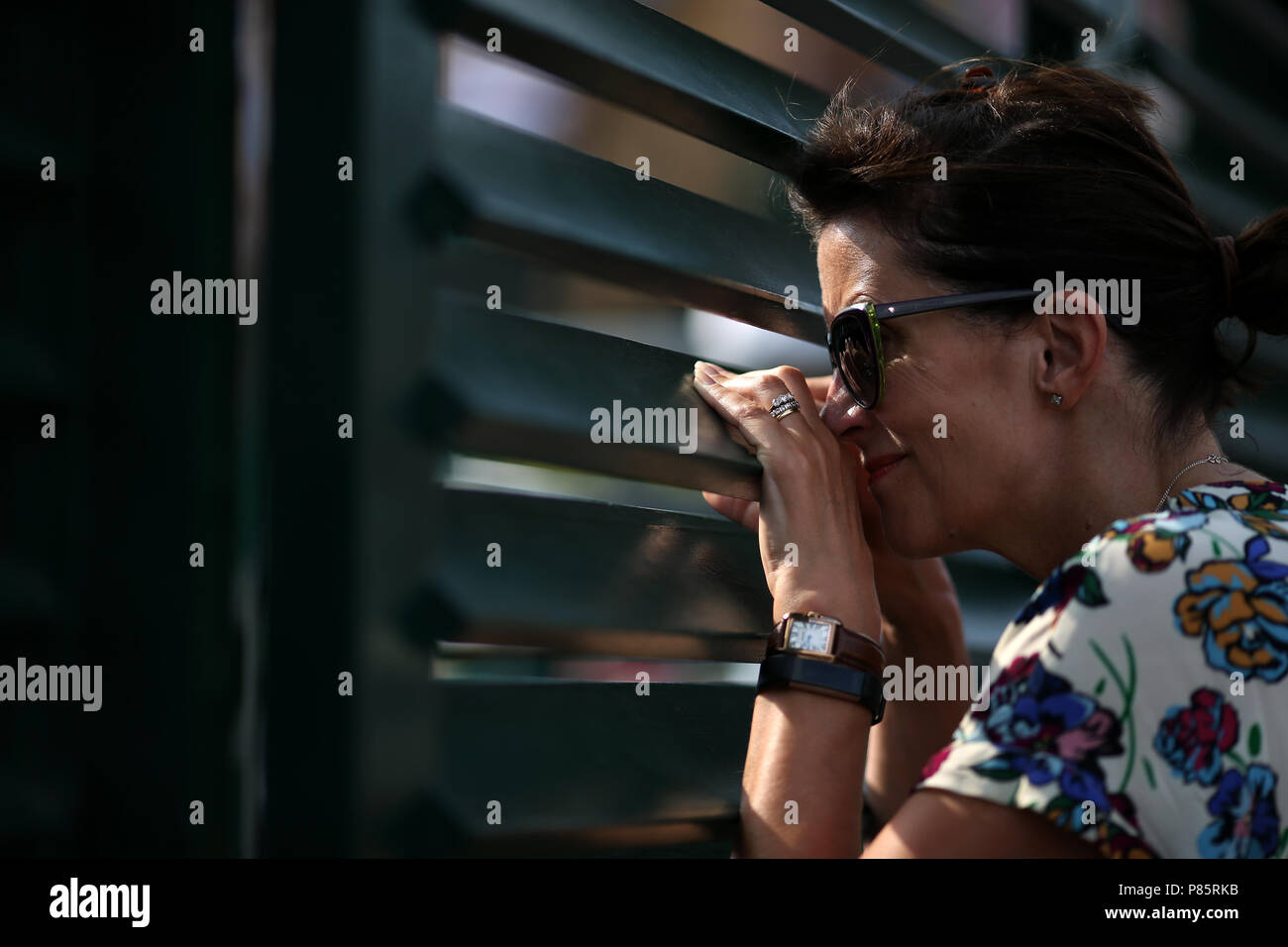 Un spectateur regarde à travers une clôture pour avoir une vue de l'action le septième jour des Championnats de Wimbledon au All England Lawn tennis and Croquet Club, Wimbledon.APPUYEZ SUR ASSOCIATION photo.Date de la photo: Lundi 9 juillet 2018.Voir PA Story tennis Wimbledon.Le crédit photo devrait se lire: Steven Paston/PA Wire.RESTRICTIONS : usage éditorial uniquement.Aucune utilisation commerciale sans le consentement écrit préalable de l'AELTC.Utilisation d'images fixes uniquement - aucune image mobile à émuler.Pas de superposition ou de suppression des logos de sponsor/annonce.Pour plus d'informations, appelez le +44 (0)1158 447447. Banque D'Images