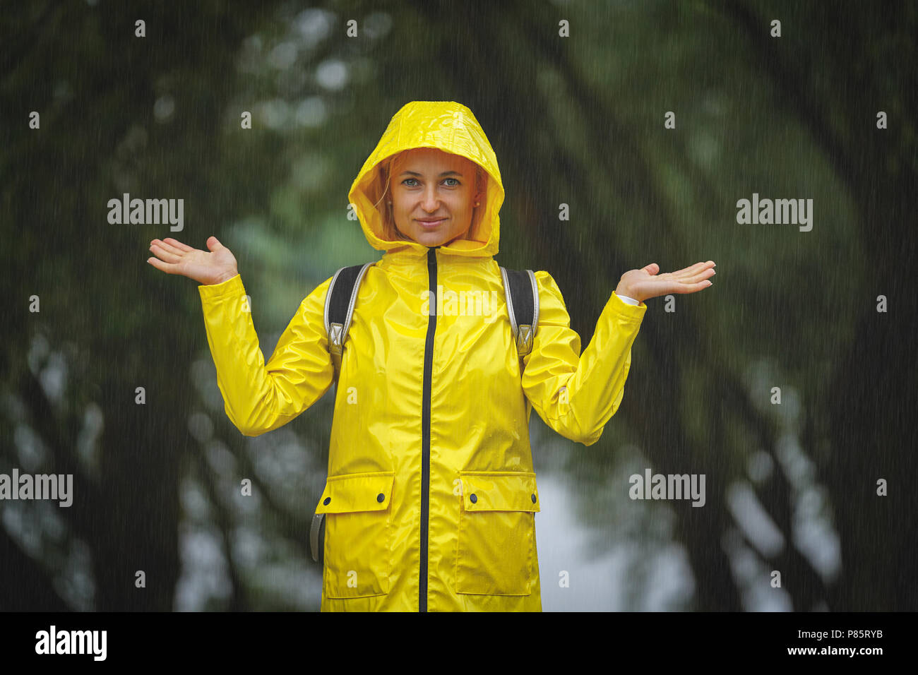 Heureux jeune femme en imperméable jaune sous la pluie Photo Stock - Alamy