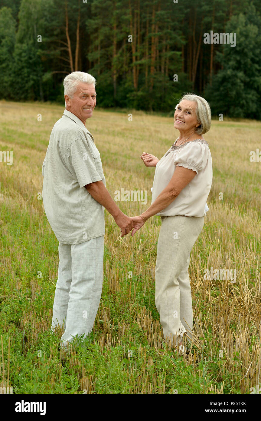 Senior couple reposant à champ d'été Banque D'Images