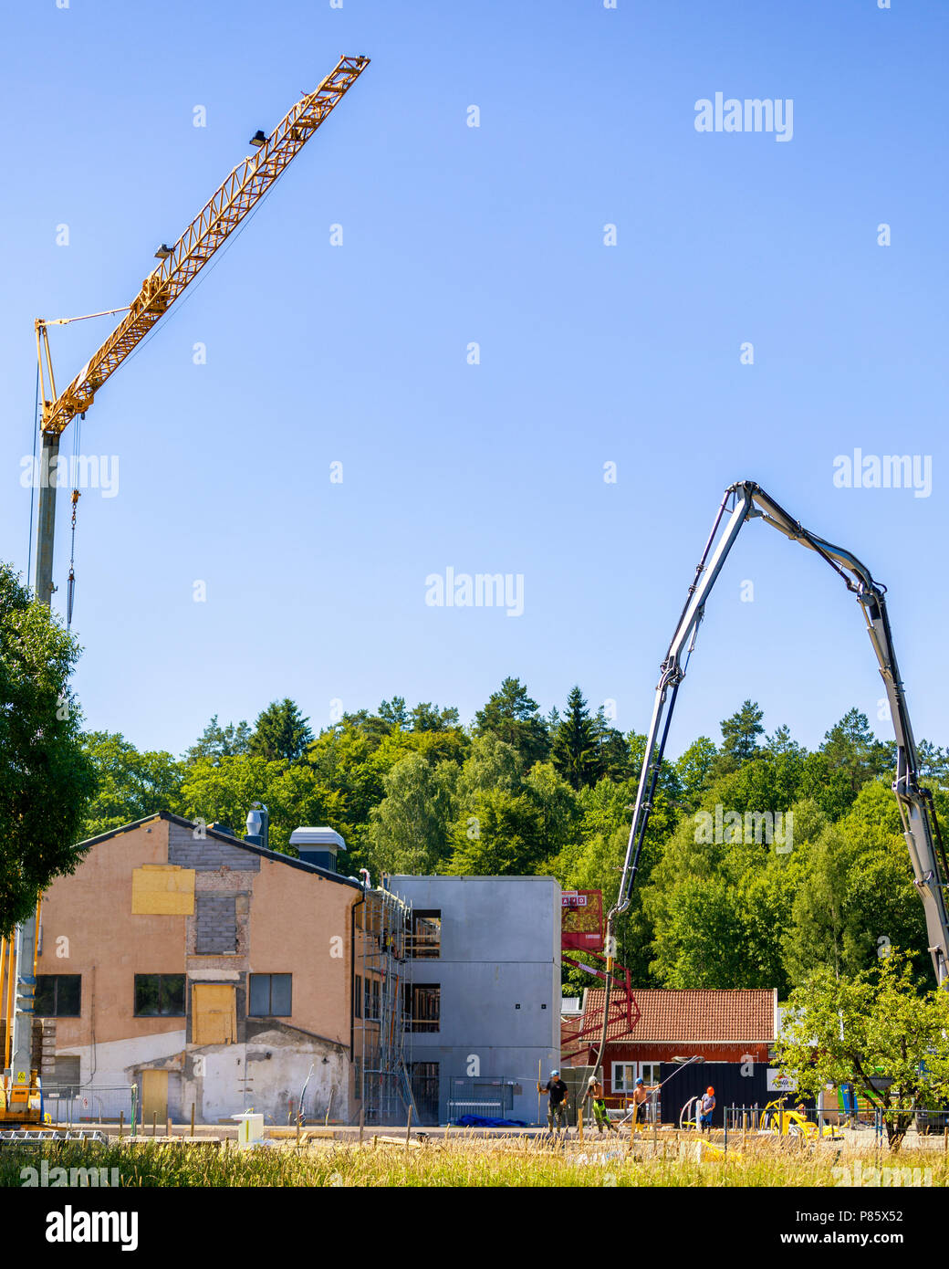 Les constructeurs travaillent avec très grande grue coulage de béton at construction site Banque D'Images