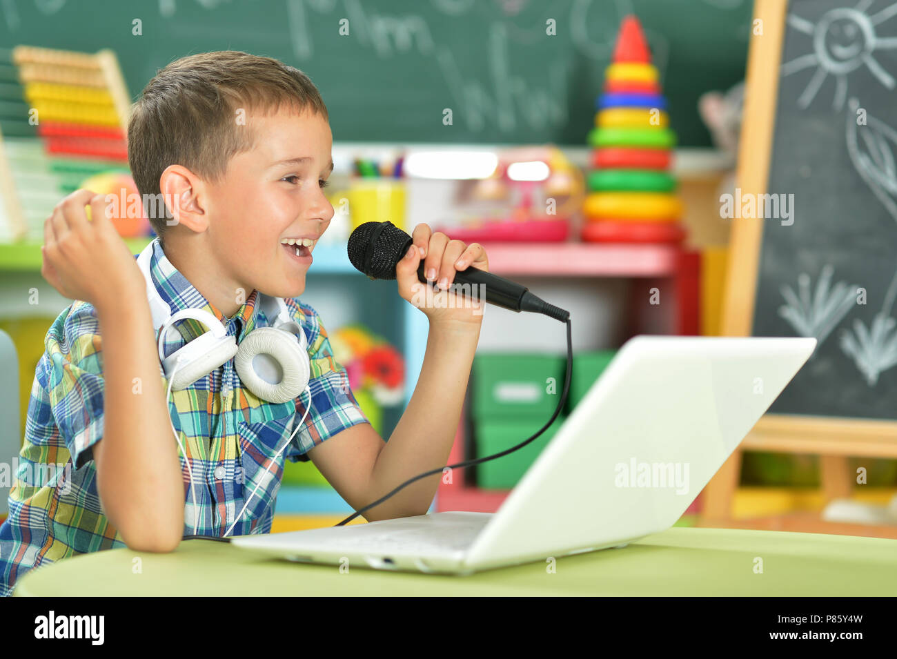 Boy singing karaoke Banque D'Images