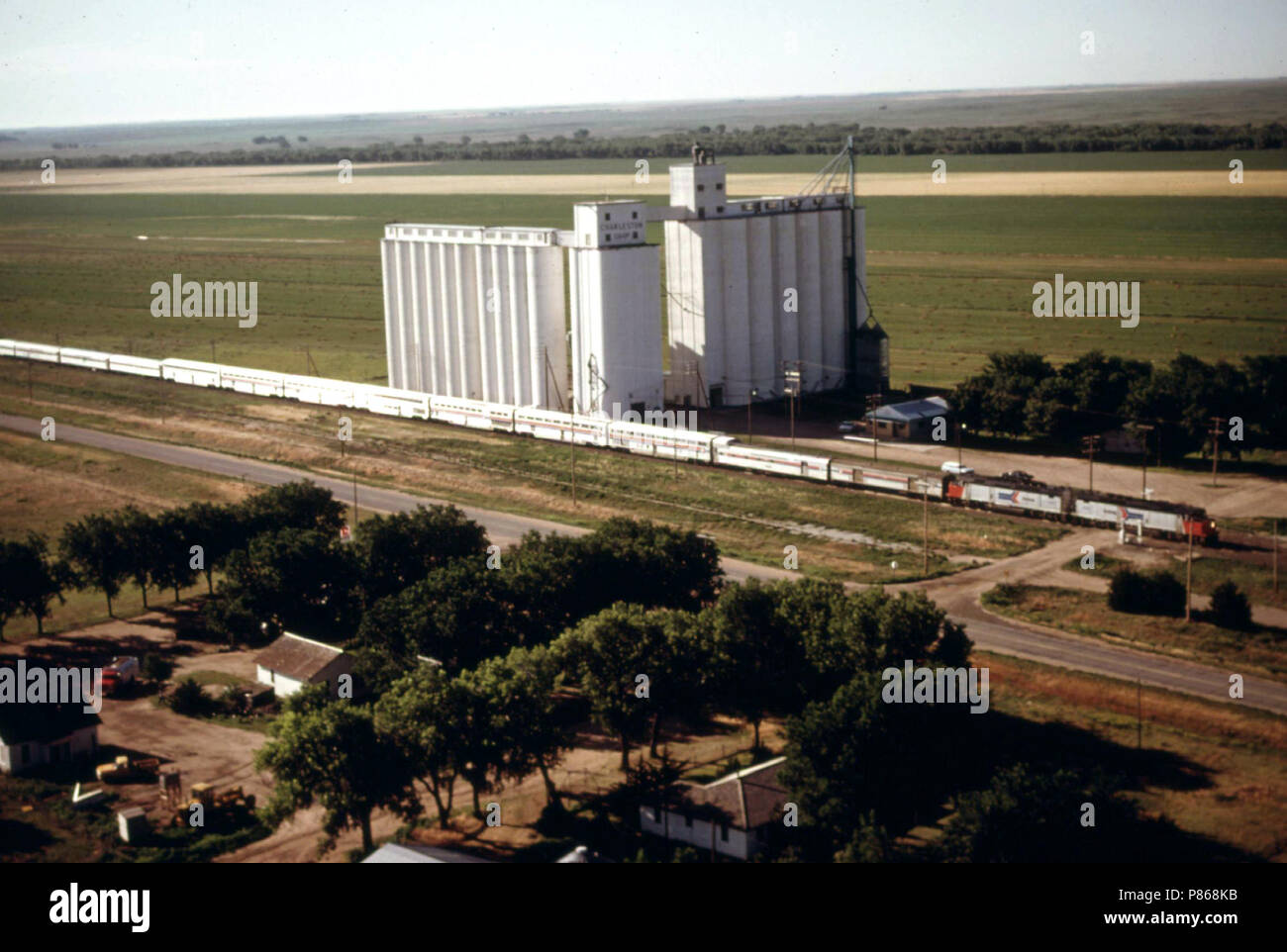Vue aérienne du sud-ouest de Limited (train # 3) lorsqu'il passe une ferme coopérative ascenseur entre Dodge City et Garden City, New York, juin 1974 Banque D'Images