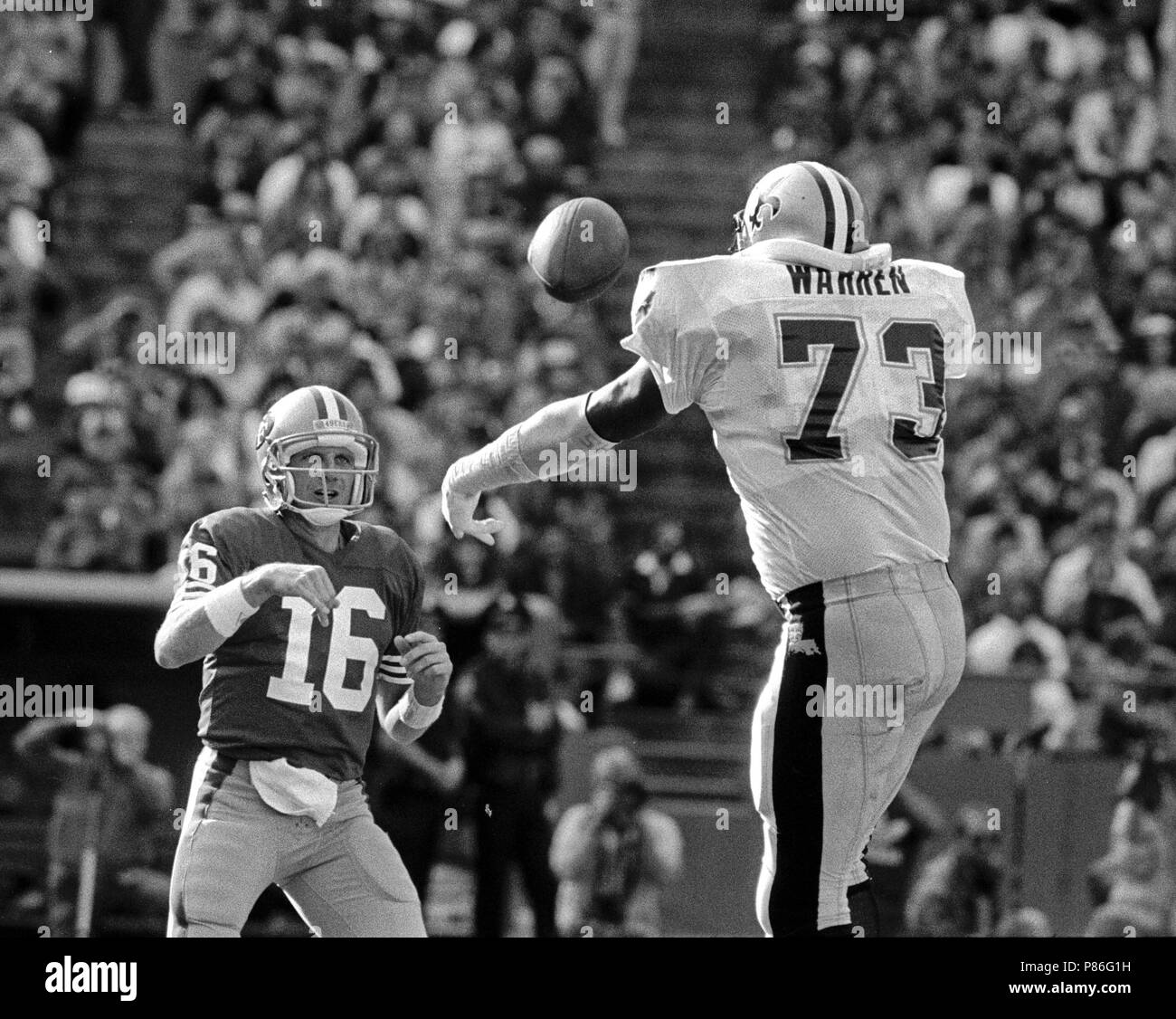 15 novembre 1987 - San Francisco, Californie, États-Unis - San Francisco 49ers vs New Orleans Saints à Candlestick Park Dimanche, 15 novembre 1987. Saints beat 49ers 26-24. San Francisco 49ers Quarterback Joe Montana (16) passe au-dessus de New Orleans Saints défensive fin Frank Warren (Image Crédit : © Al Golub via Zuma sur le fil) Banque D'Images