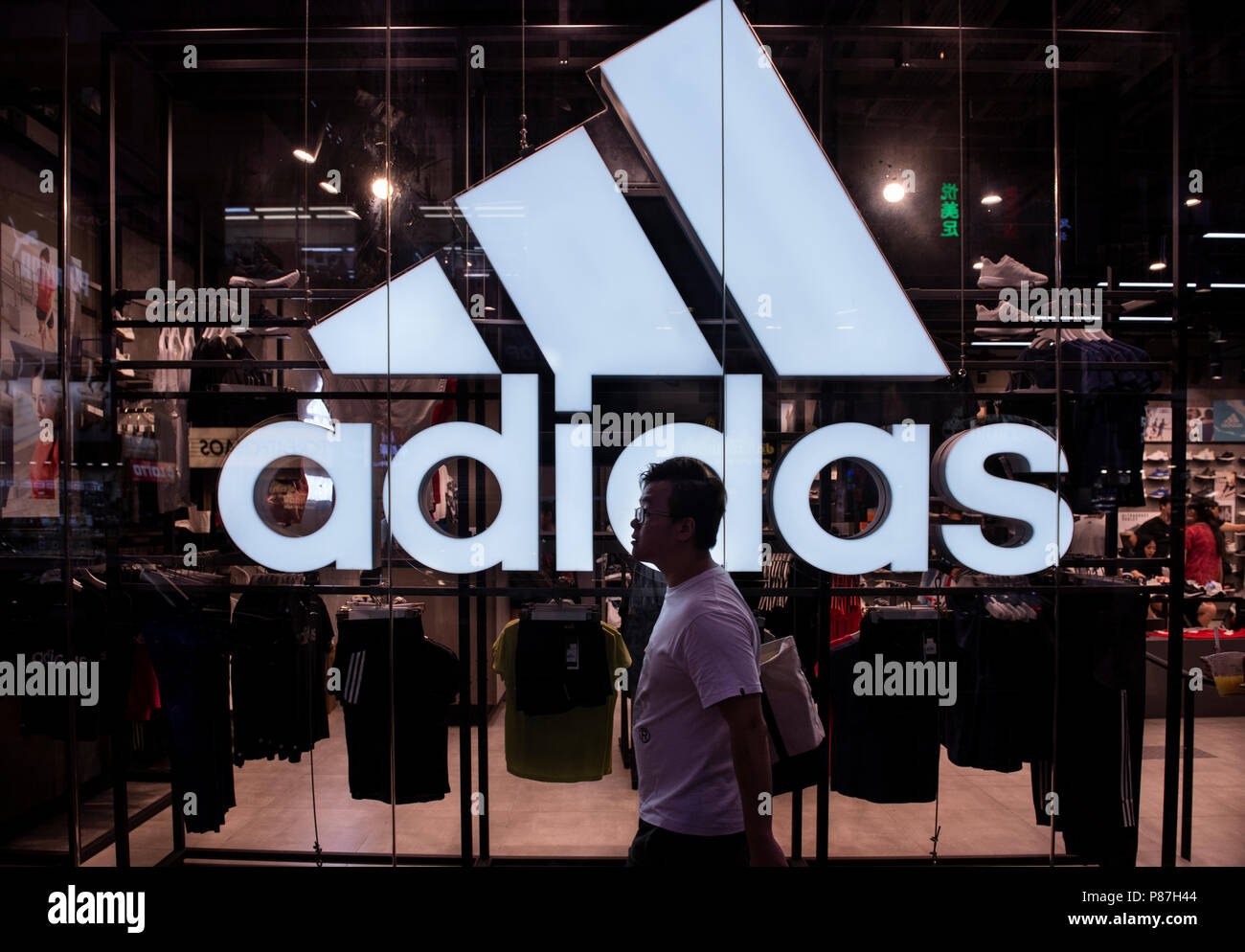 Une randonnée pédestre par une grande multinationale allemande logo Adidas et un magasin de sport à Hong Kong. Banque D'Images