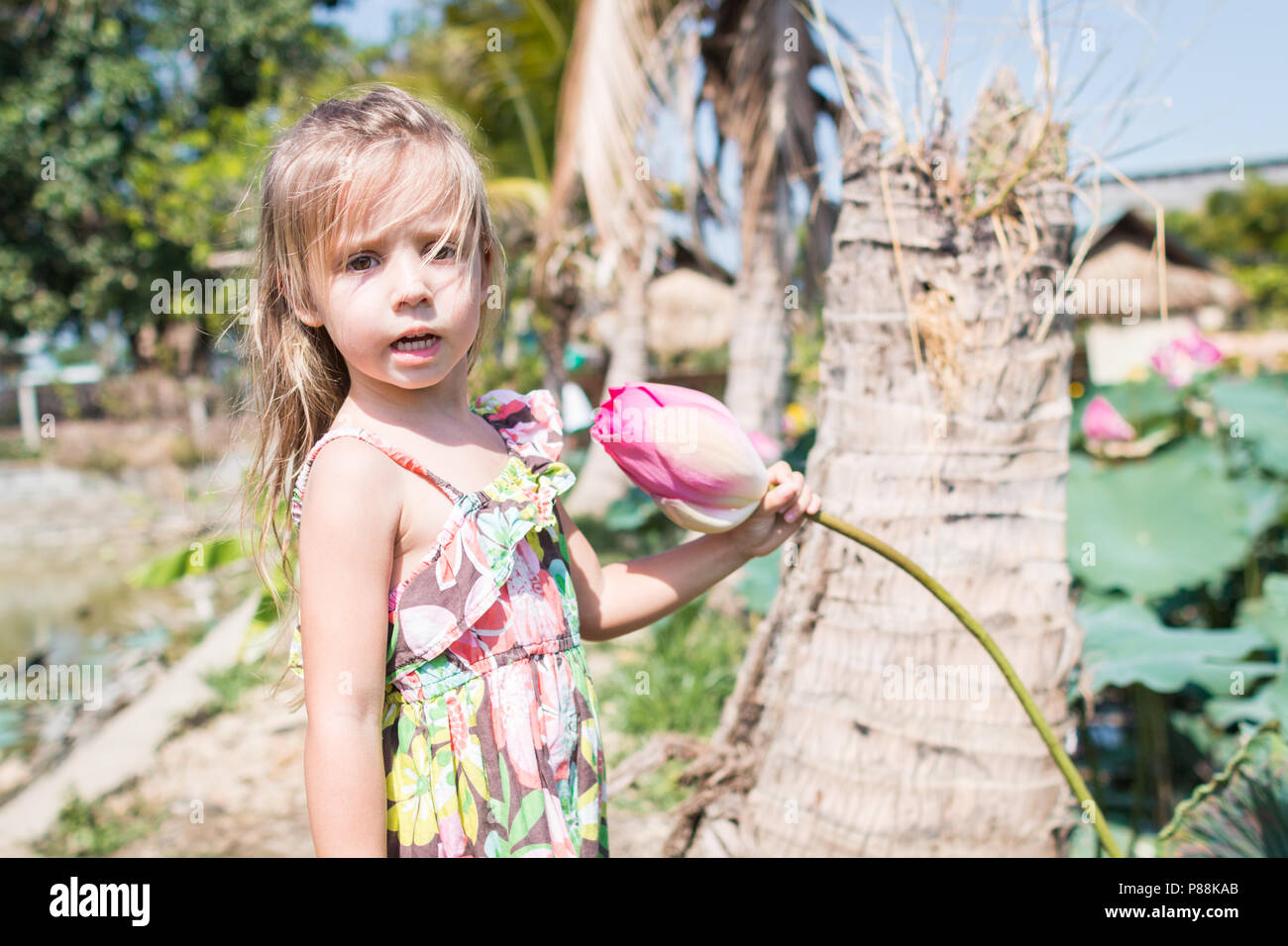 Cette belle fleur de lotus ou nénuphar. La jeune fille tenir dans ses mains une fleur et sourire Banque D'Images