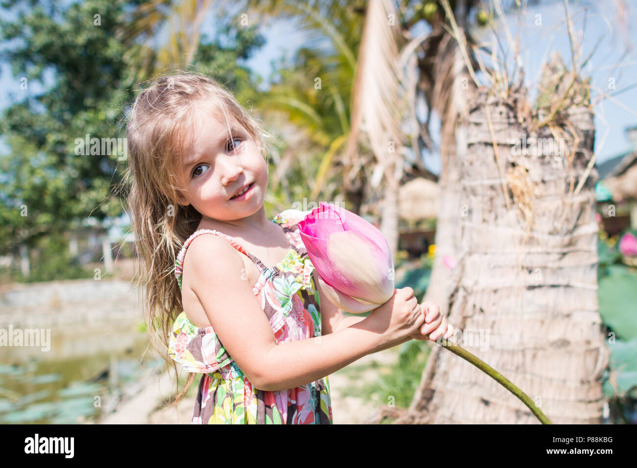 Cette belle fleur de lotus ou nénuphar. La jeune fille tenir dans ses mains une fleur et sourire Banque D'Images