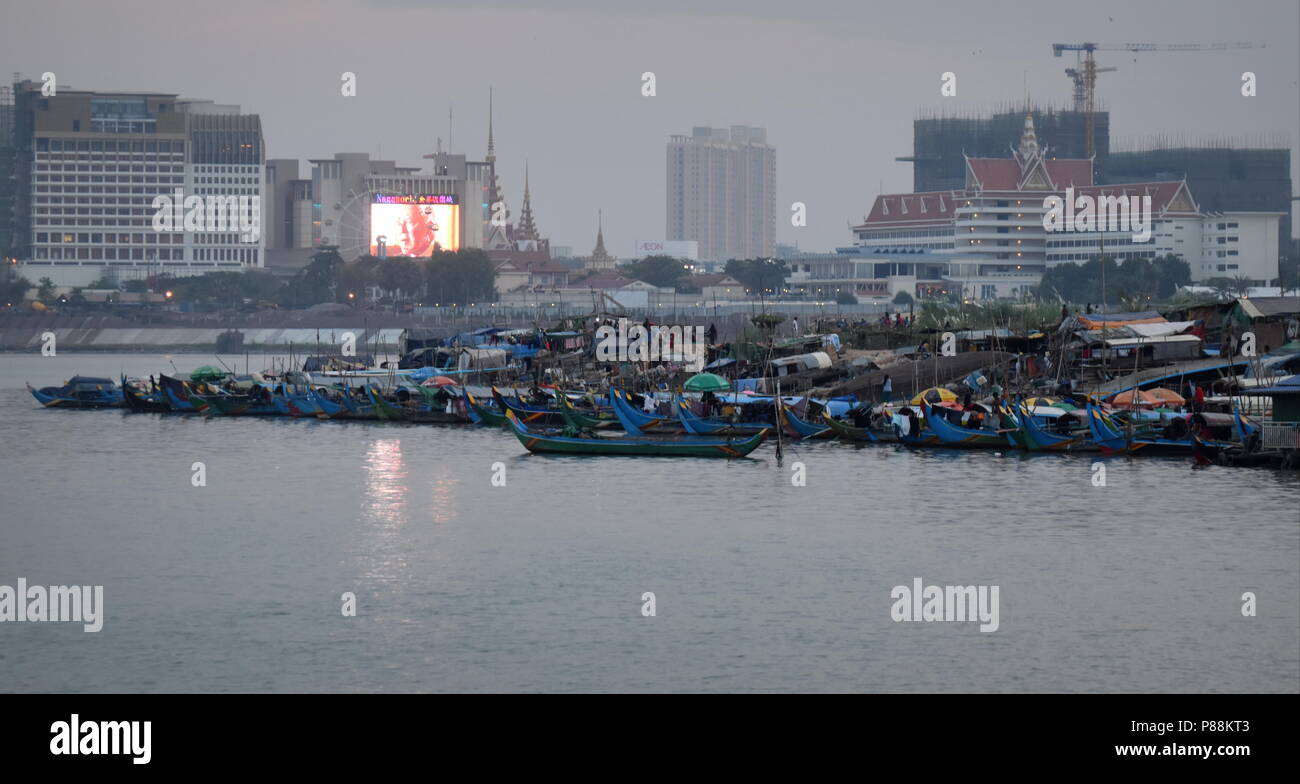 Phnom Penh skyline : contraste de paysage urbain en construction et des bateaux de pêche et la pauvreté des minorités musulmanes le long de la rivière du Mékong Banque D'Images