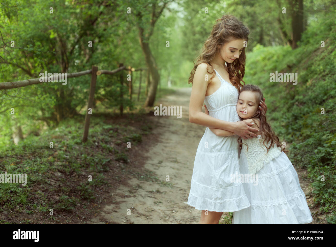 Portrait d'une jeune mère et sa fille dans la forêt. Girl hugging sa mère. Banque D'Images