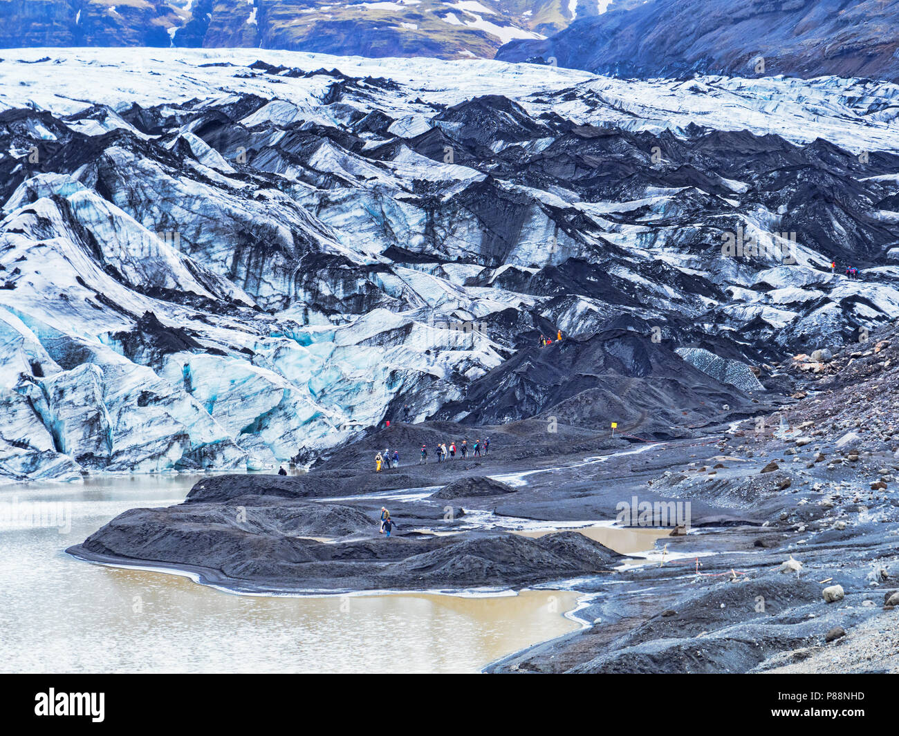 21 avril 2018 : le sud de l'Islande - Touristes à Solheimajokull Langue du glacier et le lac glaciaire. Banque D'Images