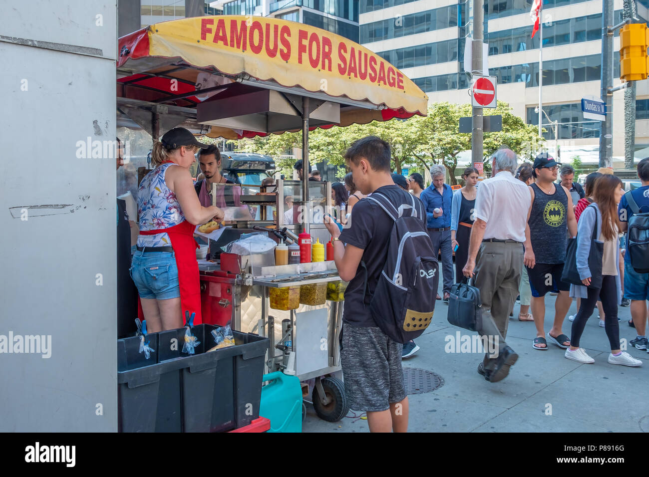 Vendeur vend ses saucisses à partir d'un panier dans une rue bondée à Toronto (Ontario) Canada. Banque D'Images
