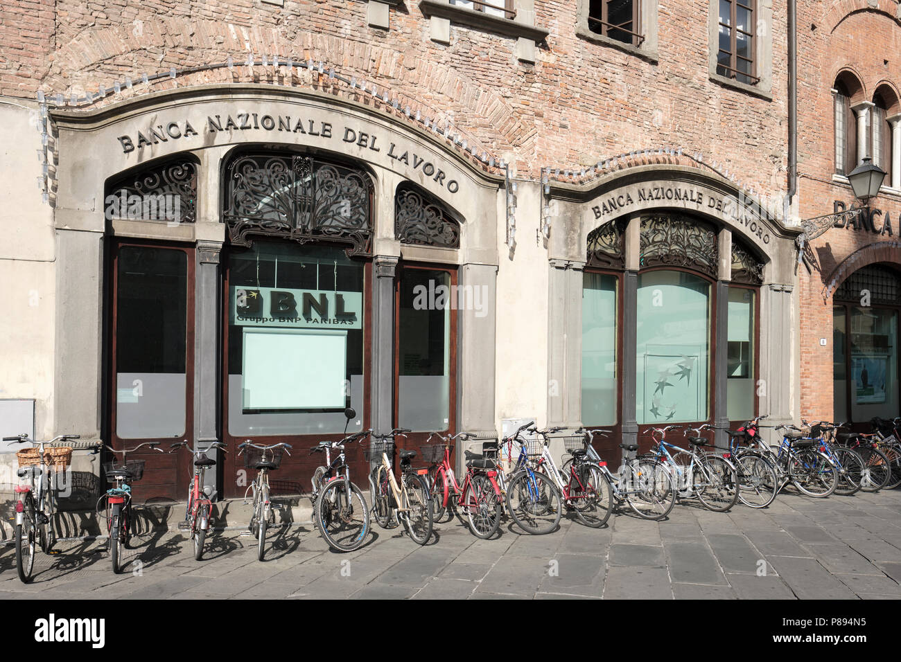 Les vélos garés jusqu'à l'extérieur des banques de la Piazza San Michele, Lucca, Toscane, Italie, Europe, Banque D'Images