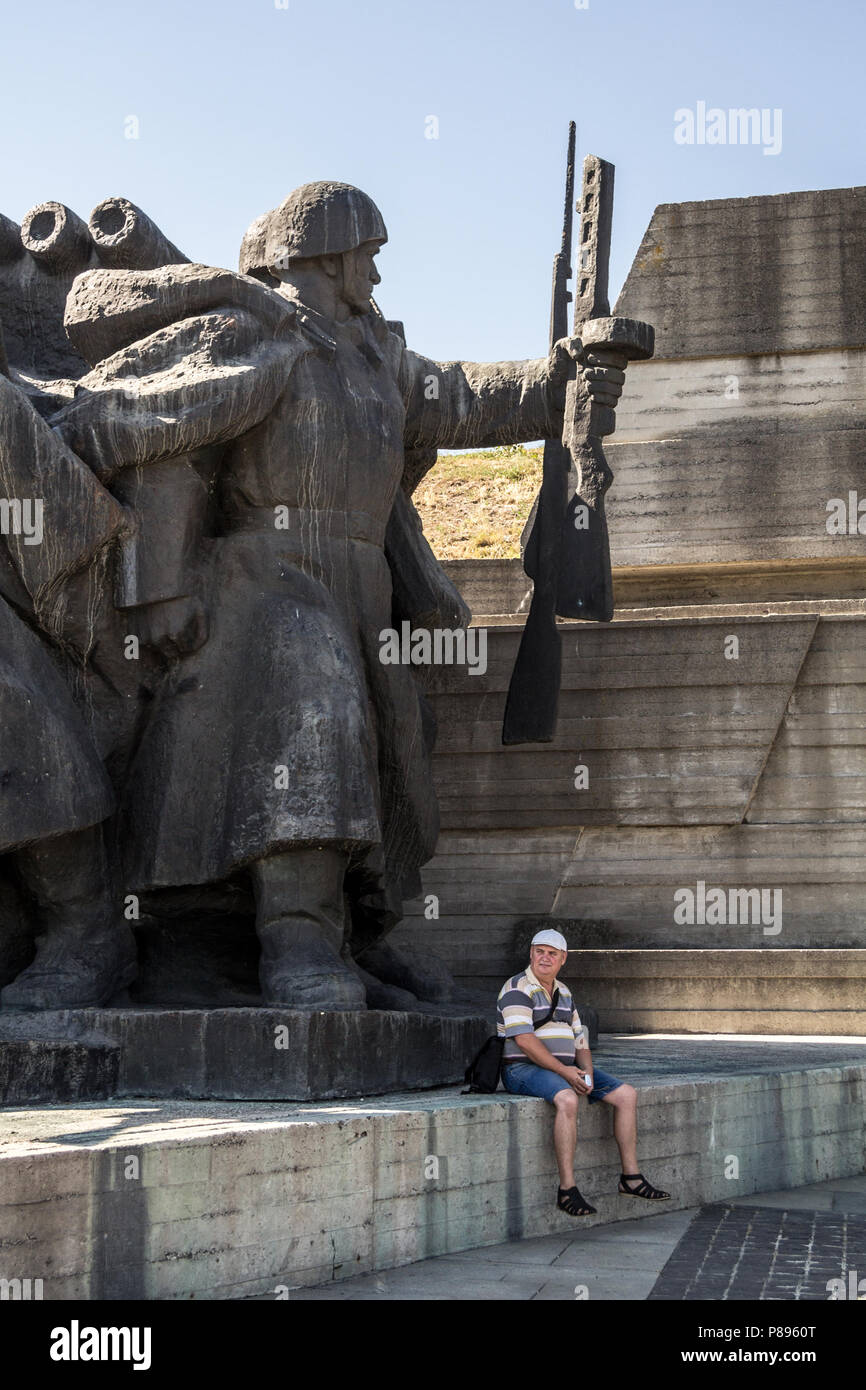 KIEV, UKRAINE - 9 août 2015 : homme assis sous une gigantesque statue communiste dans le musée de la Grande guerre patriotique, dédié à l'histoire de France Banque D'Images