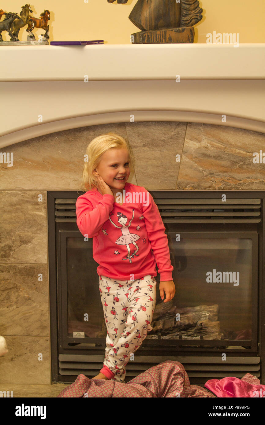 Petite, blonde, preteen girl, debout près d'une cheminée, de sourire. Communiqué de modèle # 113 Banque D'Images
