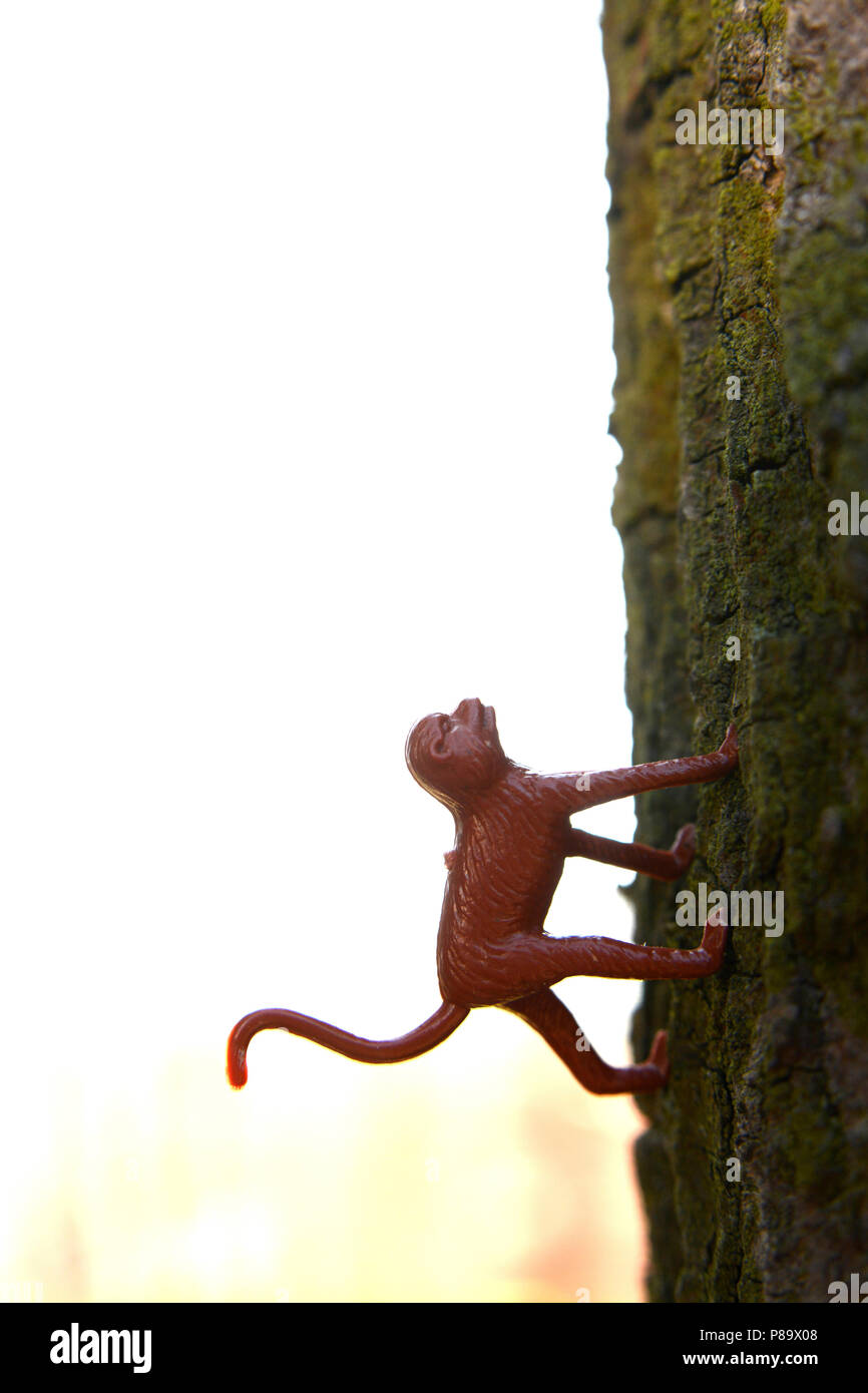 Gros plan vertical d'un singe jouet rouge sur une surface verte Banque D'Images