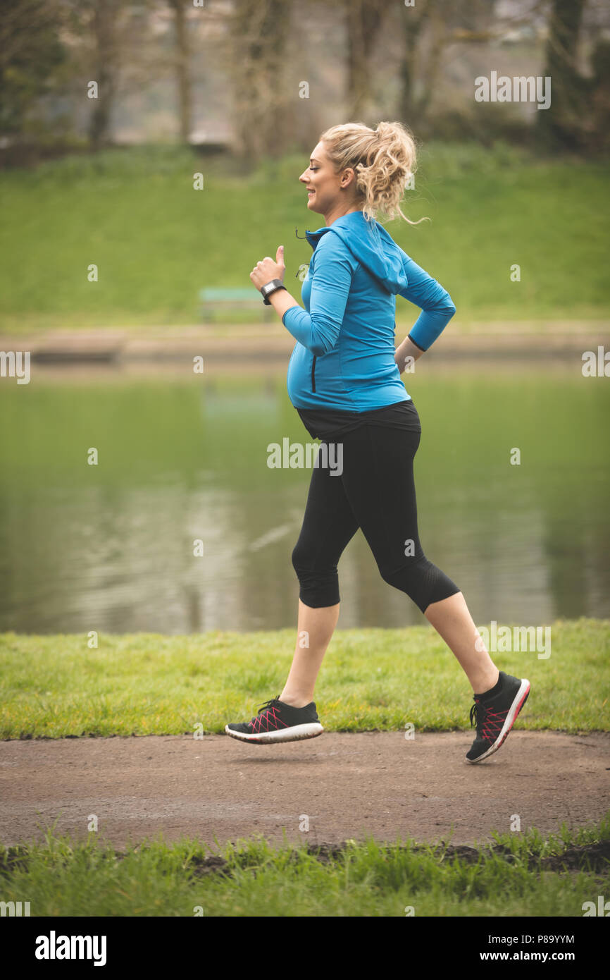 Femme enceinte le jogging dans le parc Banque D'Images