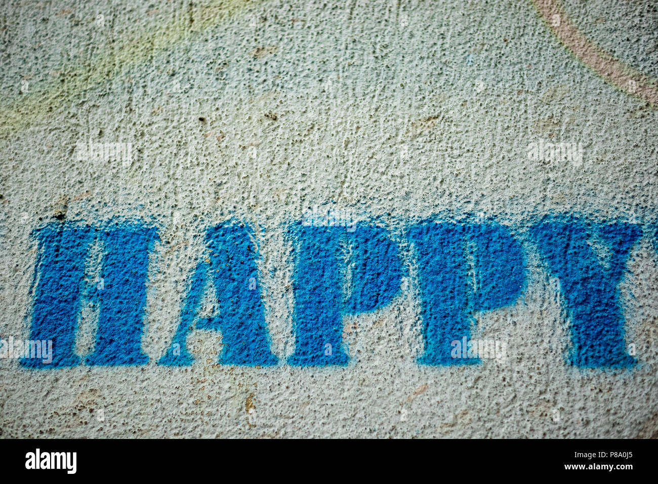 Happy blue mot peinture spray graffiti peint avec le gabarit sur le mur blanc, Close up Banque D'Images