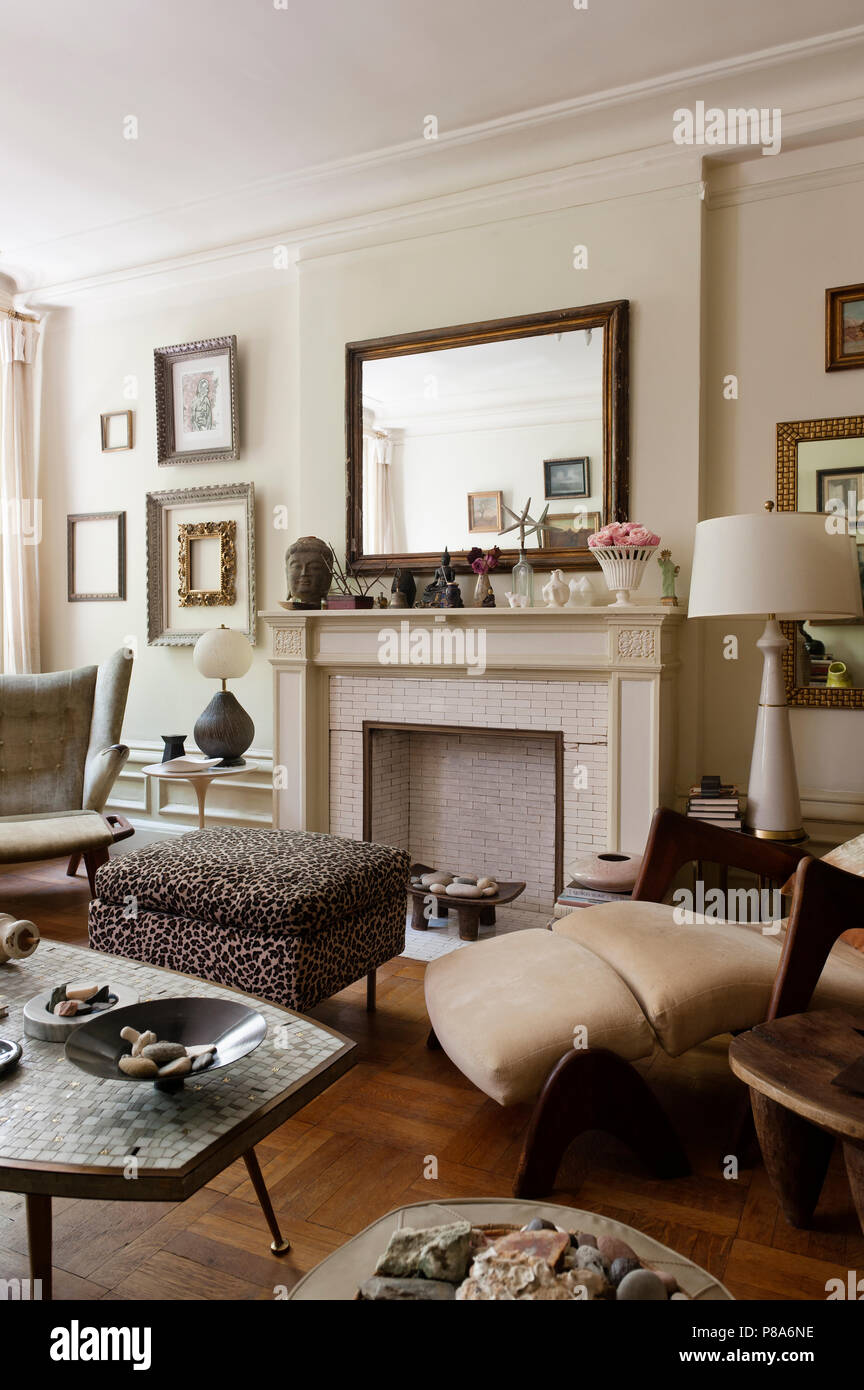Un original Papa Bear lounge chair conçu par Hans Wegner dans coin de salon avec Leopard print table mosaïque ottomans et italiens Banque D'Images