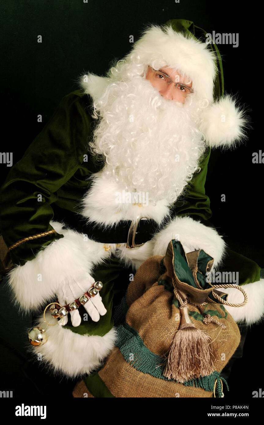 Le Père Noël en costume vert holding presents. Le Père Noël vert holding  sack Photo Stock - Alamy