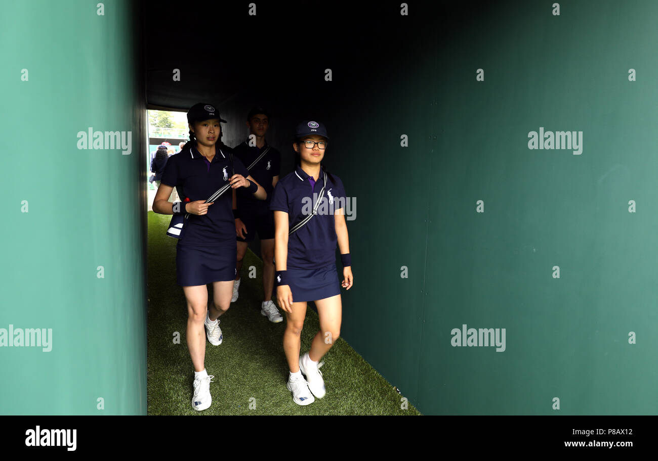 Ball garçons et filles font leur chemin sur cour 12 Le huitième jour du tournoi de Wimbledon à l'All England Lawn Tennis et croquet Club, Wimbledon. Banque D'Images