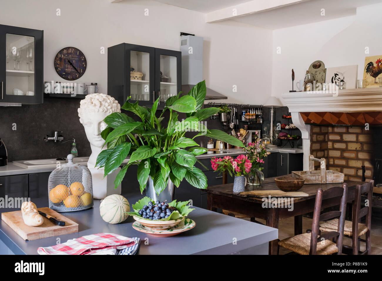 Cuisine moderne et l'unité de l'île avec cheminée ancienne conservée. 19e siècle table et chaises inégalée. Banque D'Images