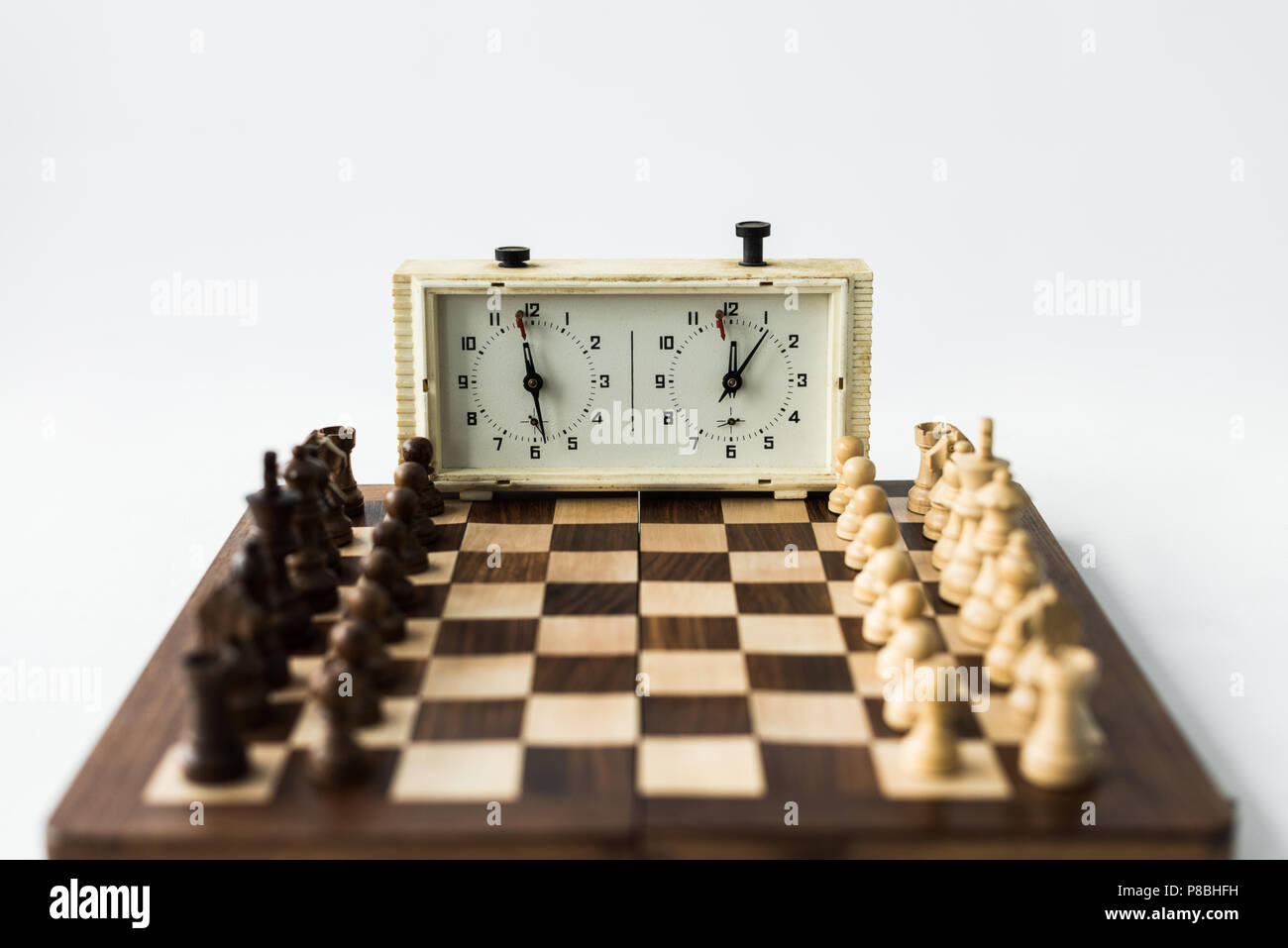 Conseil d'échecs avec les chiffres fixés pour nouveau jeu d'échecs et réveil isolated on white Banque D'Images