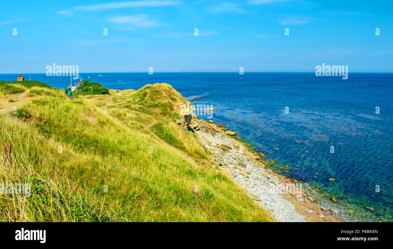 Une figure sur la falaise Point de Peveril donne sur la baie par la station de sauvetage. Banque D'Images