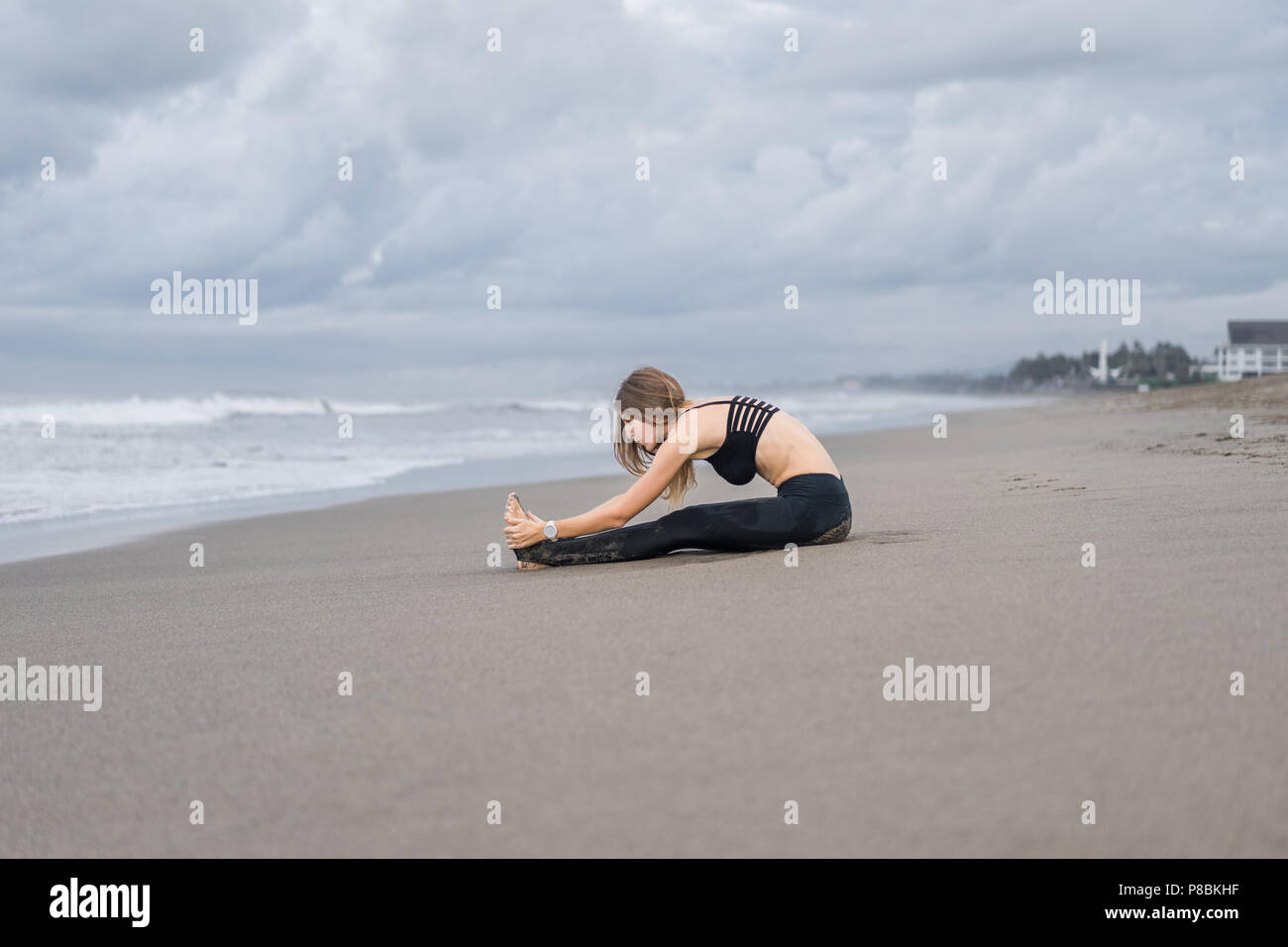 Attractive young woman practicing yoga in Caterpillar posent sur mer Banque D'Images