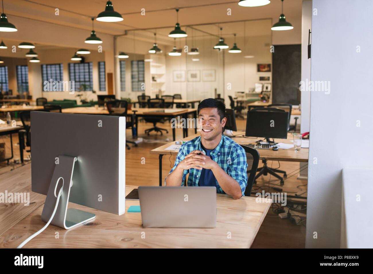 Smiling young designer travaillant à son bureau dans un bureau Banque D'Images