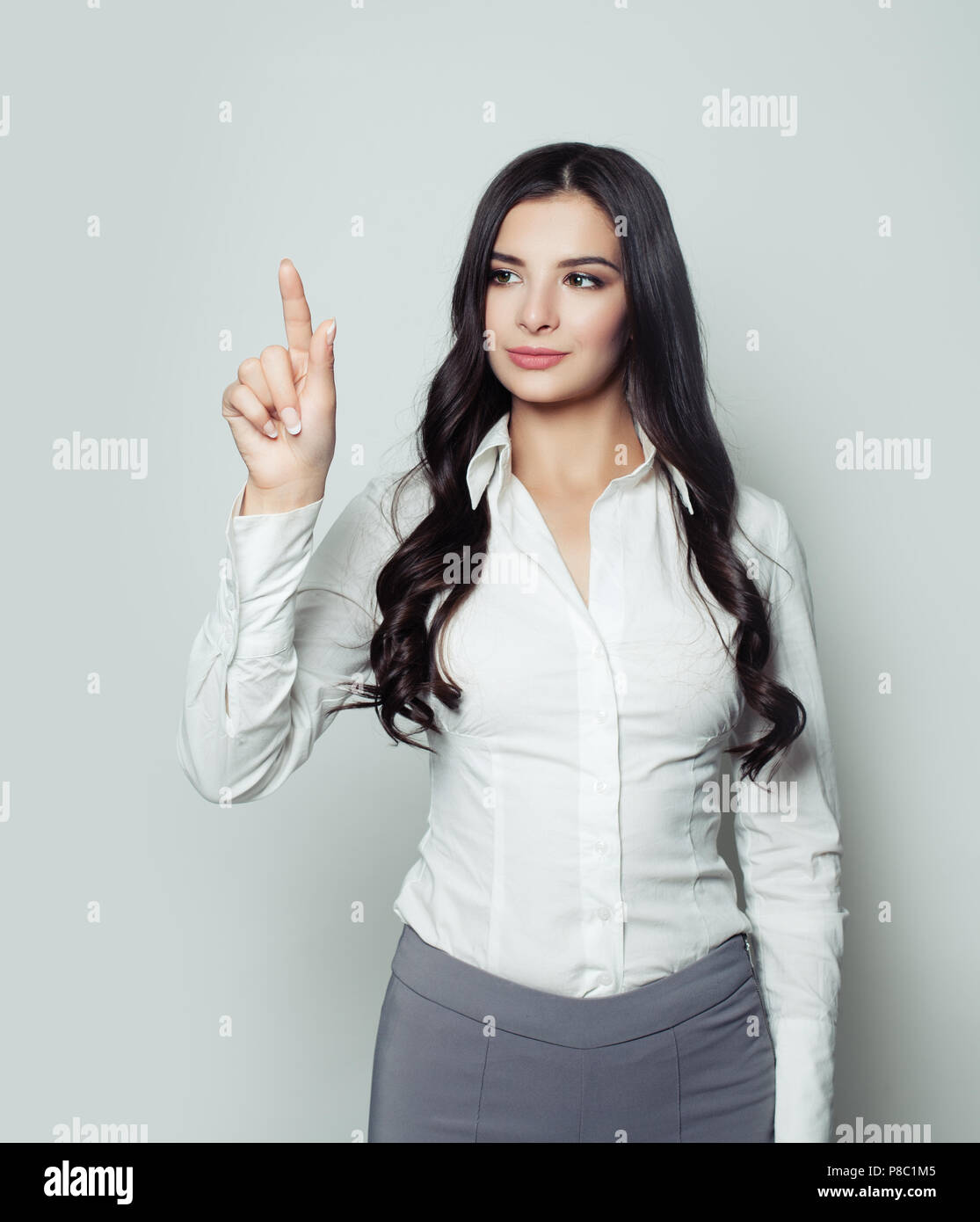 Jeune étudiante femme pointant son doigt vers le haut Banque D'Images