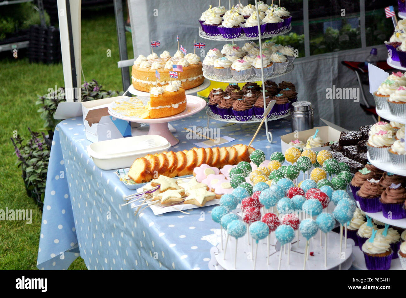 Variété de fantaisie cupcakes, sucettes et autres gâteaux sur l'affichage sur un étal du marché Banque D'Images