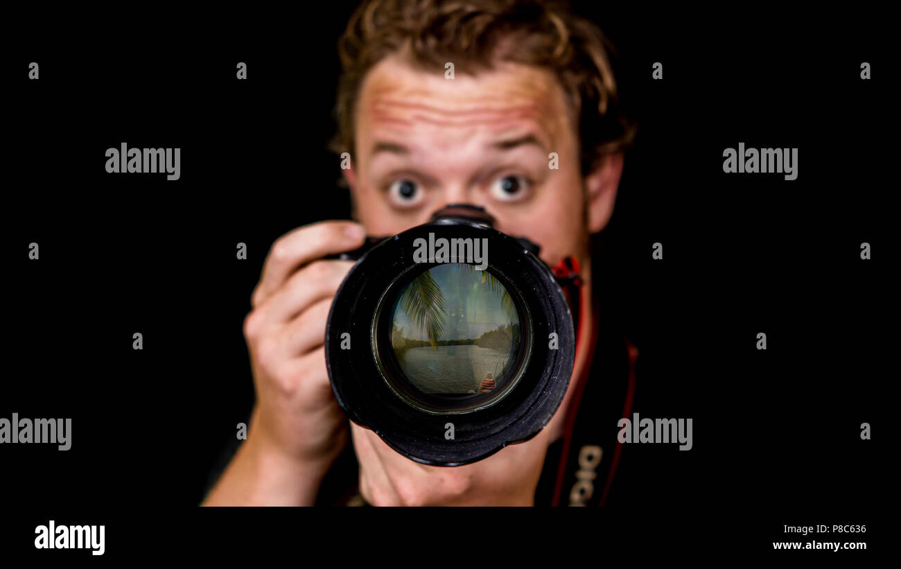 Un photographe professionnel détient son appareil près de son visage. Banque D'Images