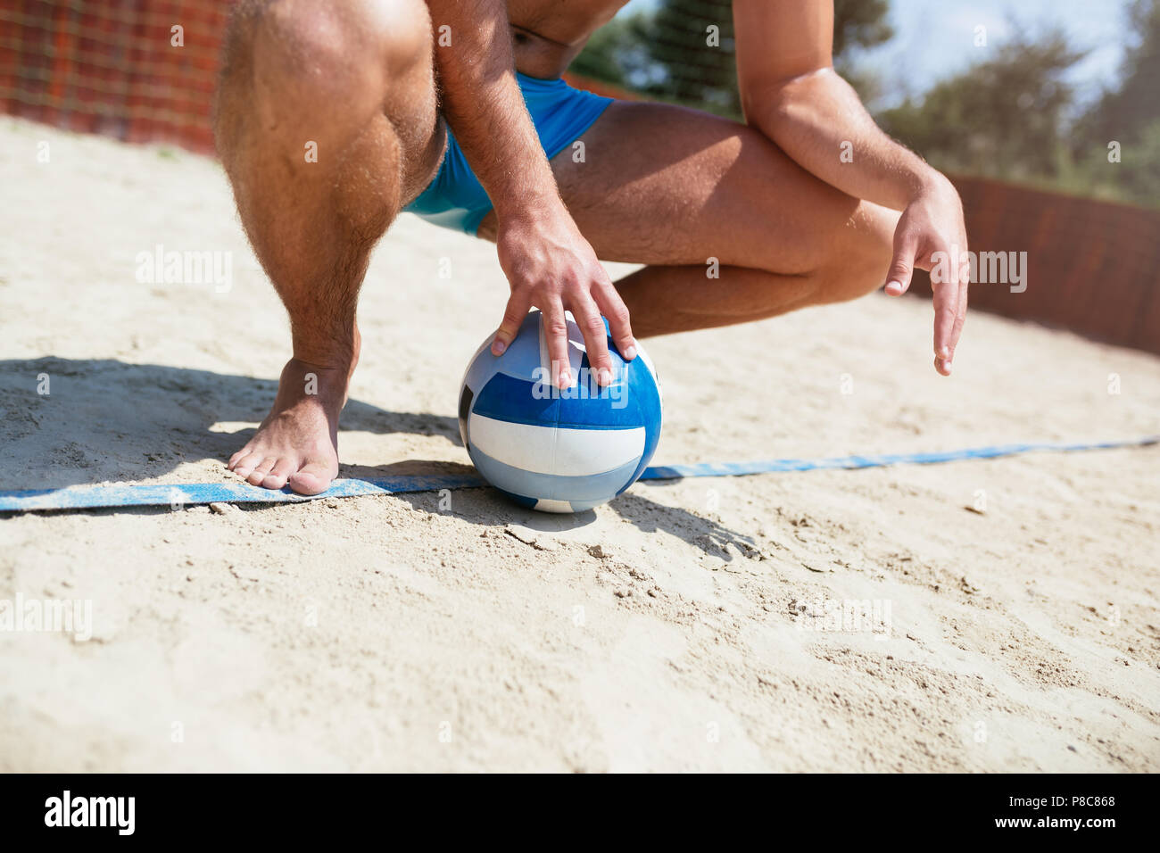 Beach-volley - bel homme jeune à jouer au volleyball de plage. Chaude journée d'été. Close up shot. Banque D'Images