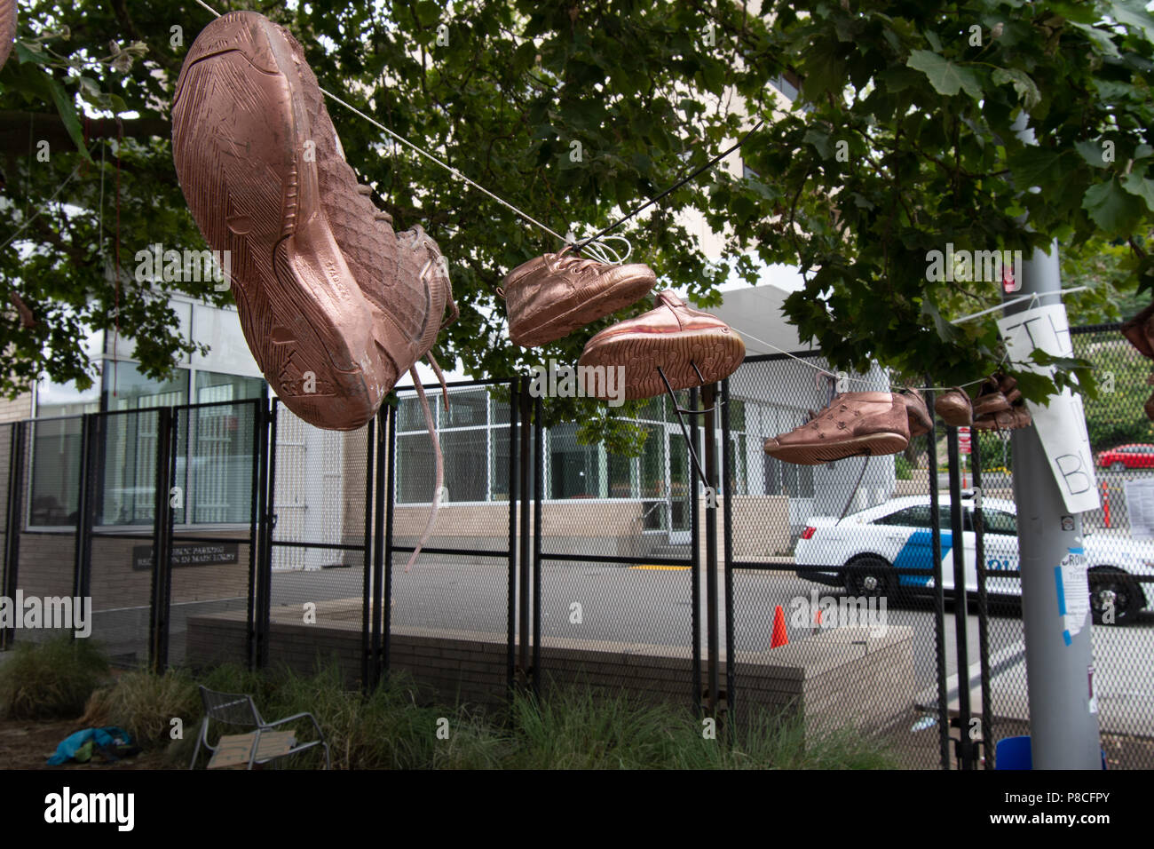Portland, USA. 10 juillet, 2018. Les chaussures pour enfants piqués jusqu'à protester contre la glace (U.S. Immigration and Customs Enforcement) de la politique de séparation de l'enfant. Le bureau de Portland dans l'arrière-plan, avec la barrière qui viole le code de la ville. Crédit : David Krug/Alamy Live News Banque D'Images