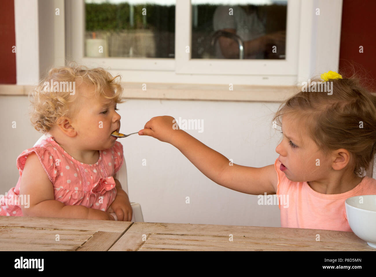 Une Fillette De Deux Ans Est De Nourrir Sa Jeune Sœur Cereales Petit Dejeuner La Fille Ainee Est 2 Et Demi Et Le Plus Jeune De 13 Mois Photo Stock Alamy